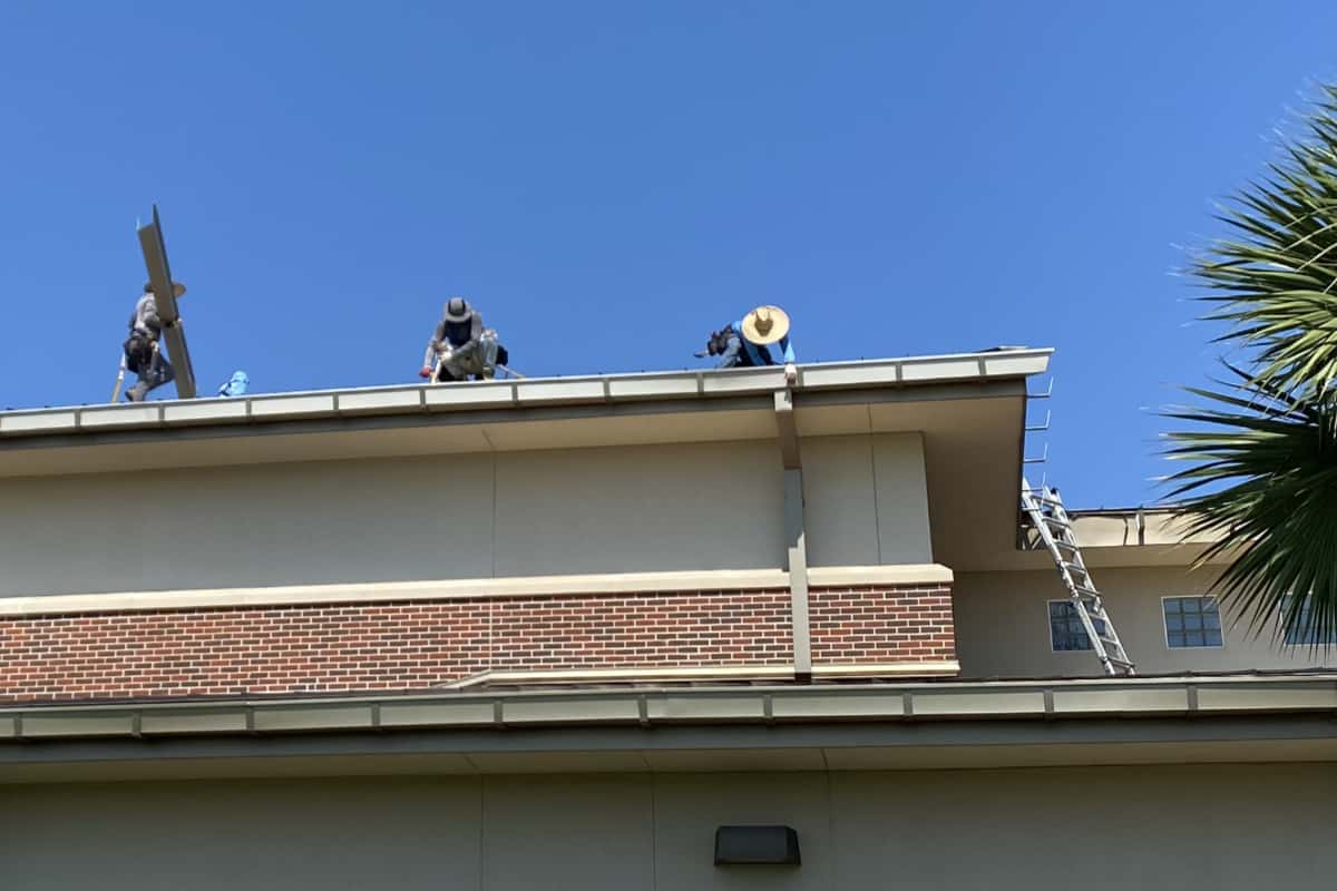 Roofers on residential restoring a roof.