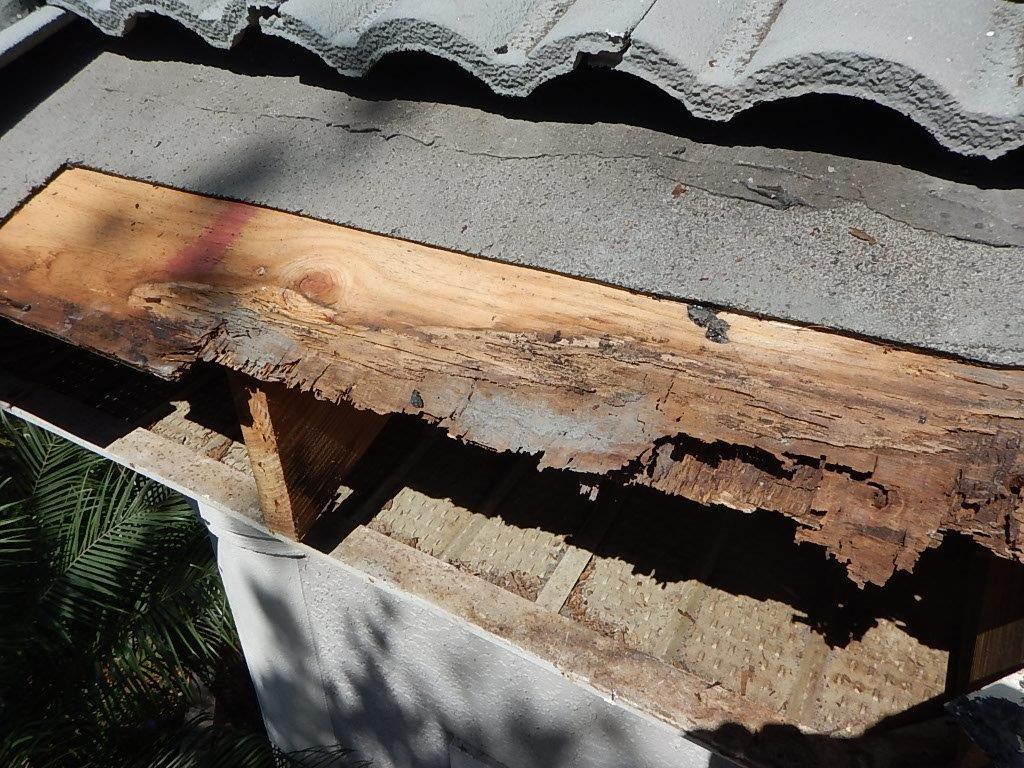 Before photo of a roof repair project of rotten wood soffit.
